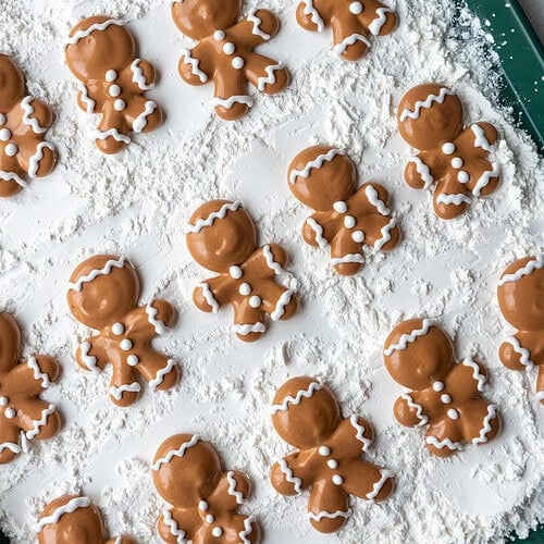 image of gingerbread men marshmallows that have been piped onto a baking sheet coated in cornstarch