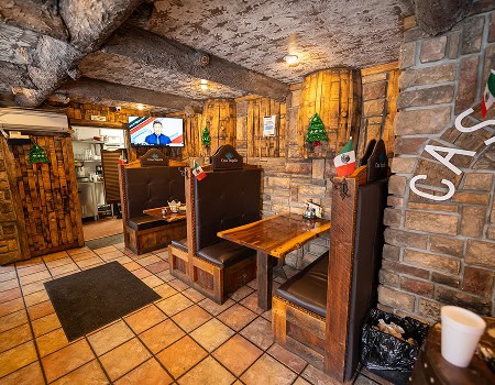 Interior view of the restaurant with wooden booths and brick walls.