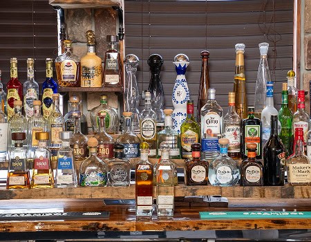 Assorted tequila bottles displayed on a bar shelf at Casa Tequila Mexican Grill & Cantina in Chicago.