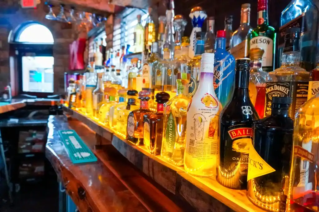Bar with a variety of tequila bottles on illuminated shelves.