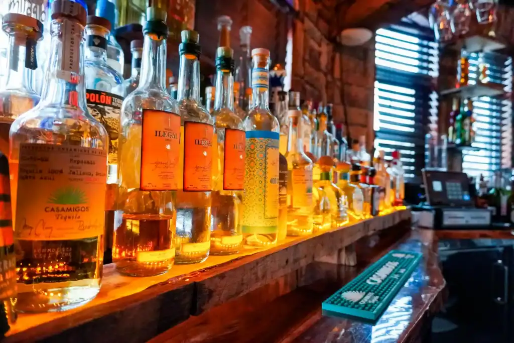 Assorted tequila bottles displayed on a wooden bar at Casa Tequila Mexican Grill & Cantina, Chicago.