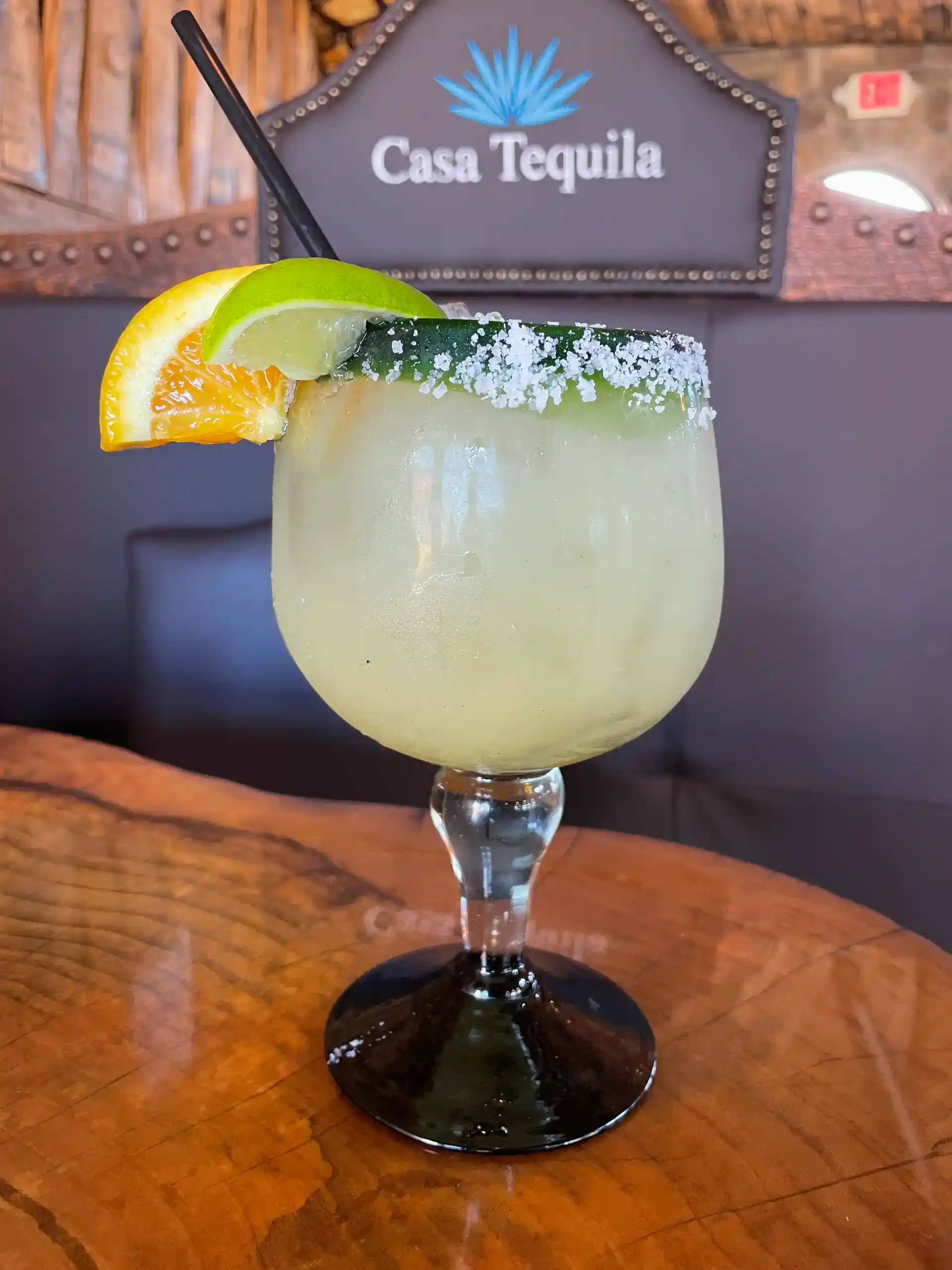 Refreshing margarita cocktail garnished with lime and orange slices at Casa Tequila Mexican Grill &.
