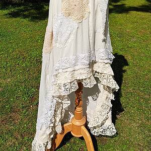 Vacker vintageklänning med broderade och spetsdetaljer, perfekt för bohemiska eller romantiska outfits, utställd på mannequindocka utomhus.