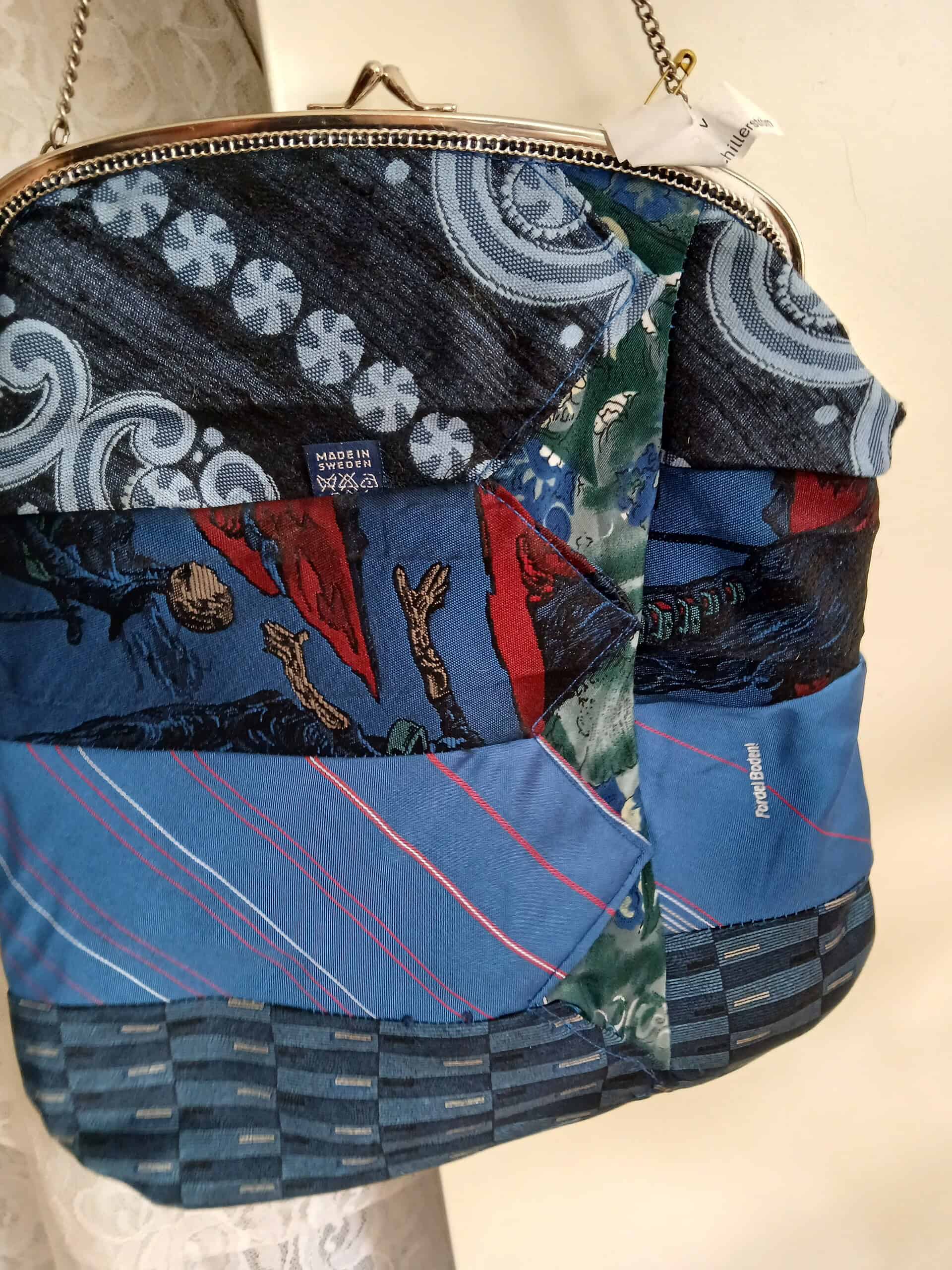 Blommig och mönstrad väska med olika tygbitar, stilrent designat i blått, rött och grönt, perfekt för vardagsbruk och modeaccessoar.