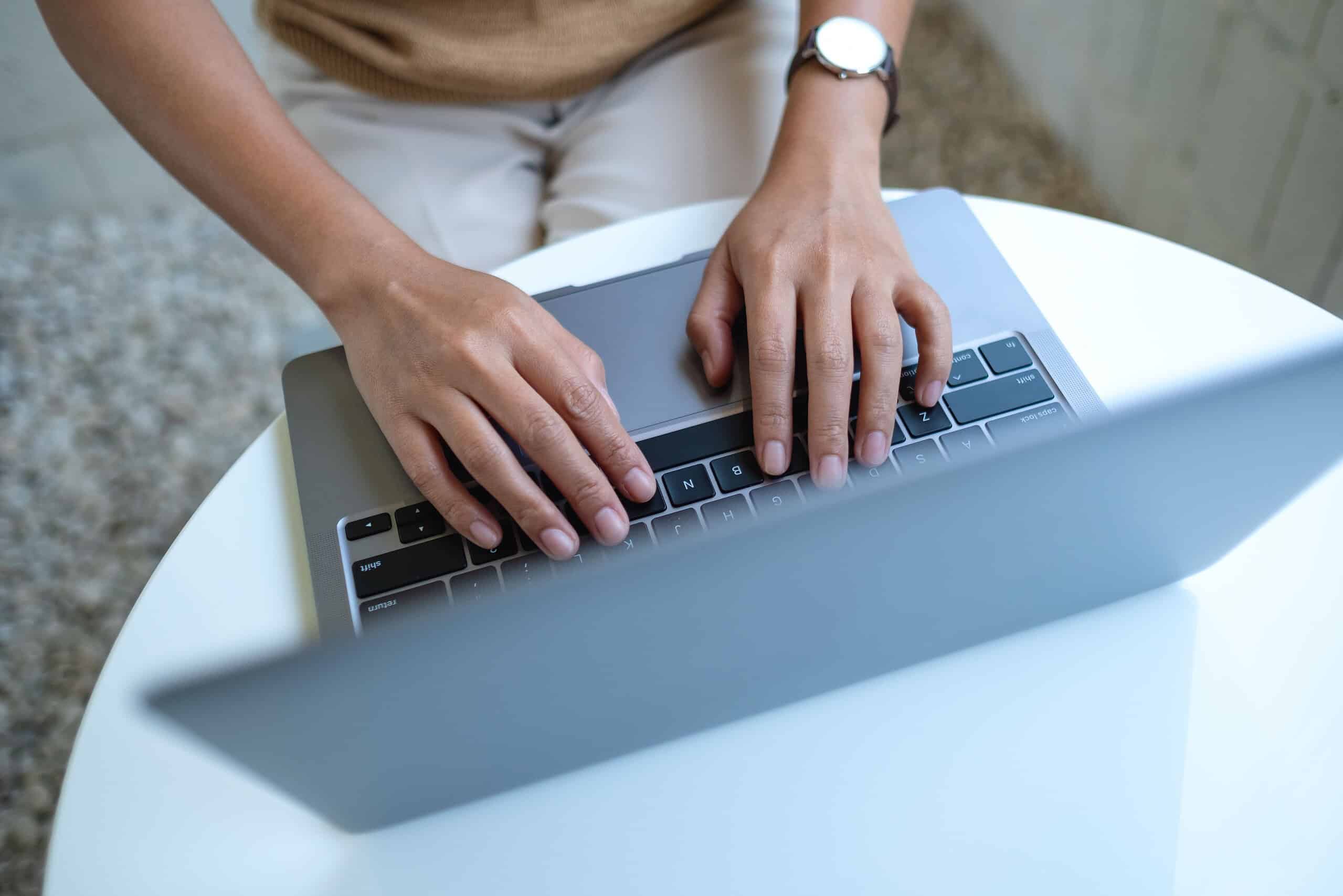Top View Image Of A Woman Working And Typing On Laptop Computer