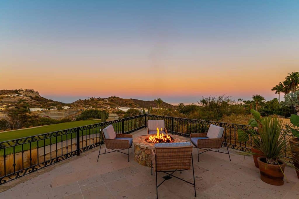 Luxury Outdoor Fireplace Overlooking Golf Course And Ocean View At Sunset, Spacious Patio With Comfortable Seating And Lush Greenery, Exclusive Real Estate At Club Campestre.