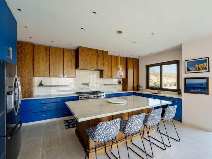 Modern Kitchen With Ocean View And Stylish Blue Cabinetry, Open Space, And Natural Light At Club Campestre Real Estate, Featuring Scenic Golf Course And Ocean Vistas.
