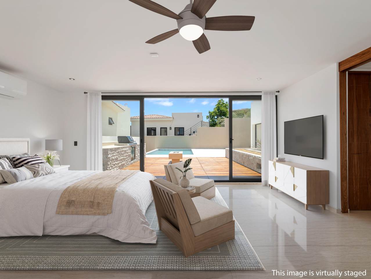 Spacious Primary Bedroom At 12 Los Valles In Club Campestre San José Del Cabo, Featuring Modern Furnishings, Marble Floors, And Sliding Glass Doors Opening To A Private Terrace With A Heated Pool View.