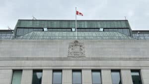 Government building with Canadian flag, representing stability and governance.