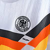 Camiseta de fútbol con logo de la federación alemana, diseño innovador y colores activos.