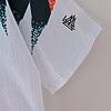 Camiseta con diseño gráfico y logotipo en blanco, negro, rojo y azul, de estilo urbano y moda contemporánea.