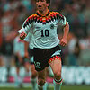 Jugador de fútbol con uniforme de Alemania en movimiento en el campo.