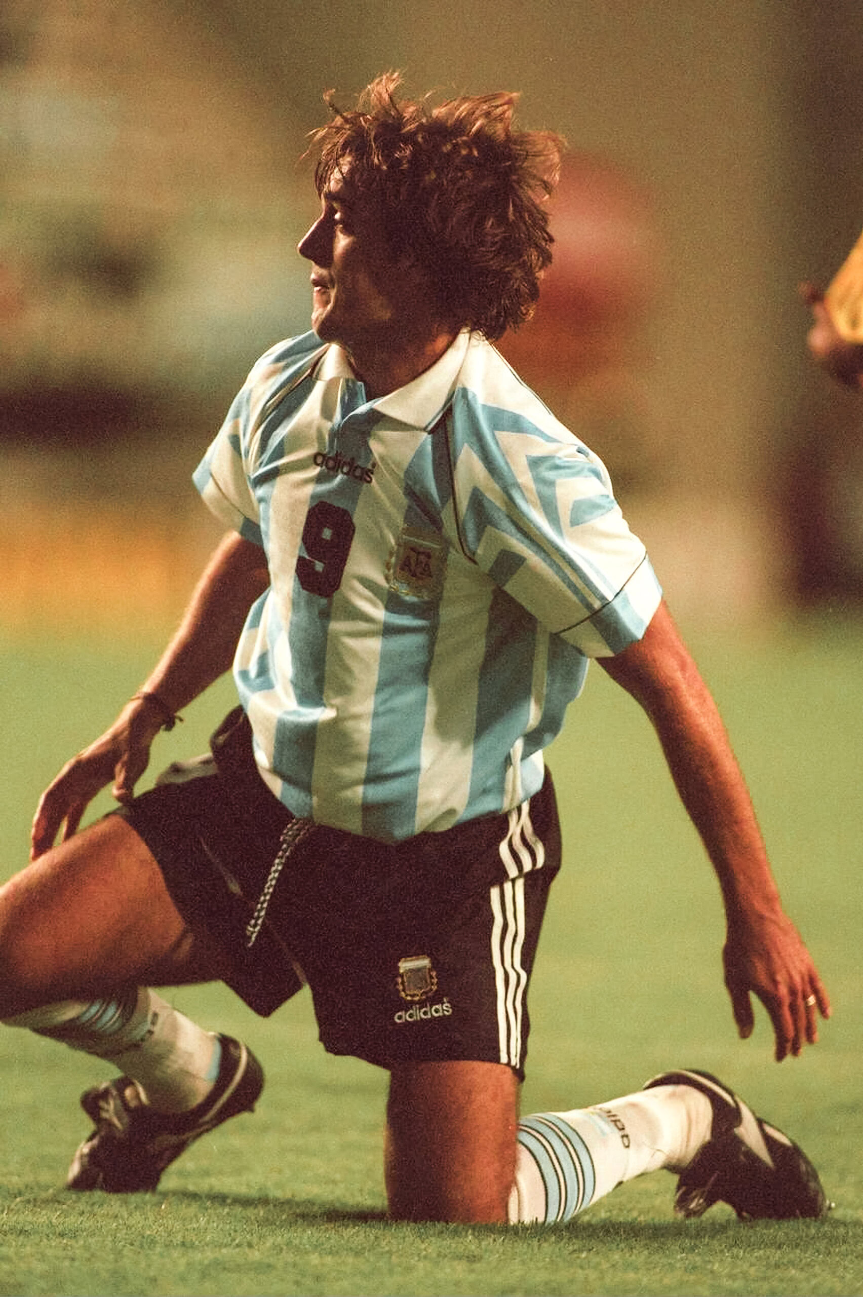 Atl text: Jugador de fútbol argentino en acción, camiseta de Argentina, estilo vintage.
