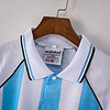 1. Camiseta clásica de fútbol Adidas con rayas celestes y blancas en colgador de madera.