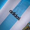 Camiseta de Adidas con diseño de rayas en azul y blanco, ideal para actividades deportivas y casuales.