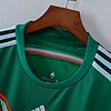 Camisa deportiva Adidas verde con detalles en blanco y negro para entrenamiento y deportes.