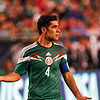 1. Jugador de fútbol mexicano con camiseta de la selección, capitán en el campo.