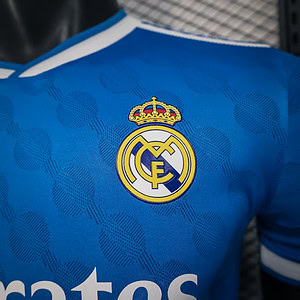 Logo del escudo del Real Madrid en camiseta deportiva azul con detalles y diseño exclusivo.