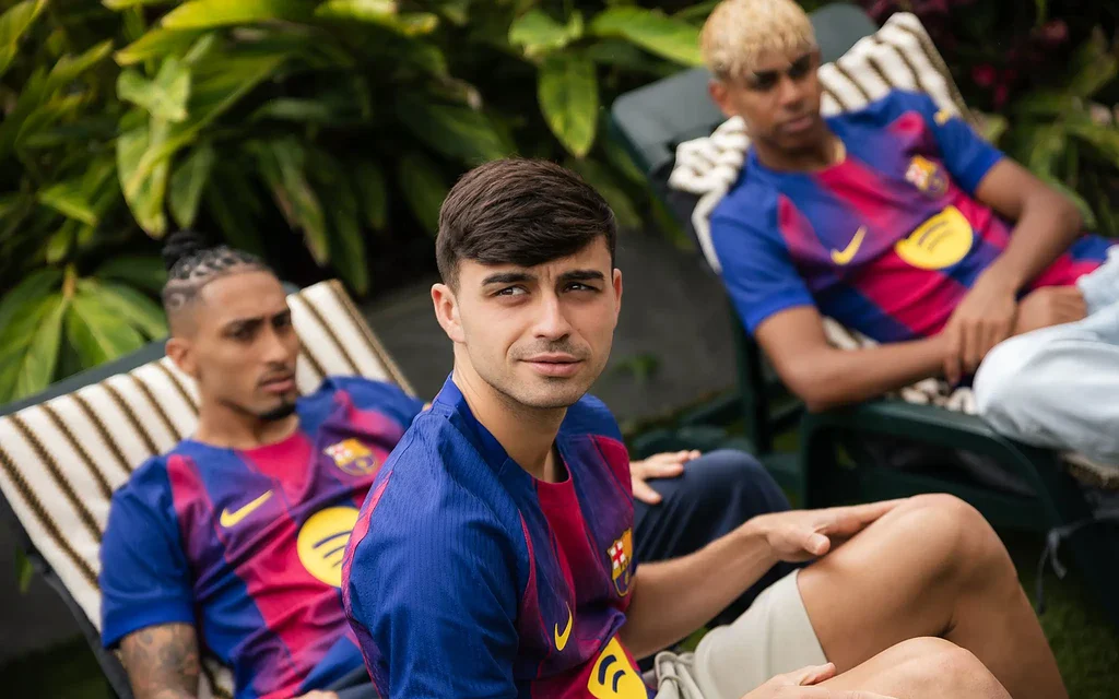 Jóvenes deportistas en relajación con camisetas de FC Barcelona, estilo urbano y moderno.