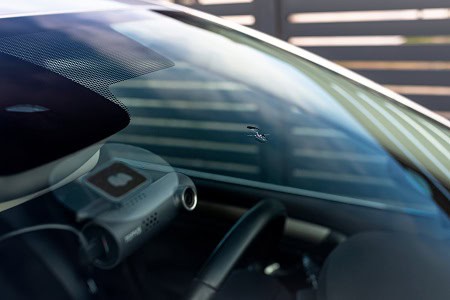 Car windshield with calibration sticker for auto glass repair and calibration.