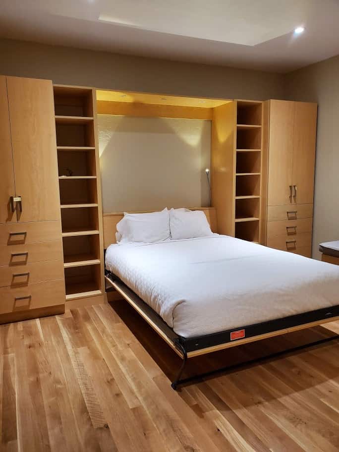 Custom bedroom closet with built-in shelves and cabinets for storage.