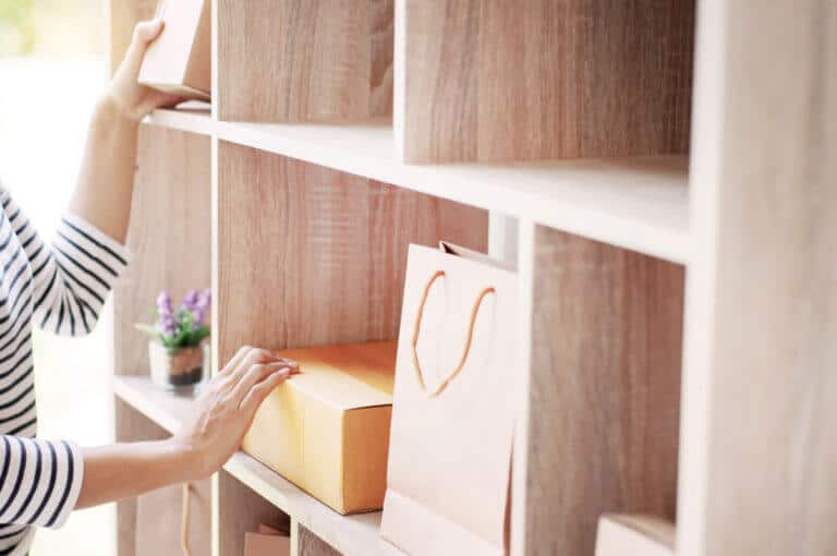 Custom wooden storage shelves with boxes and bags in a modern closet.