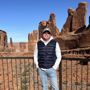 Man enjoying scenic view of rock formations in desert landscape.