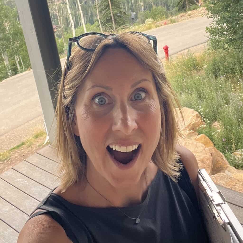 Woman with glasses on head smiling outdoors in Durango, Colorado.
