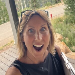 Woman with glasses on head smiling outdoors in Durango, Colorado.