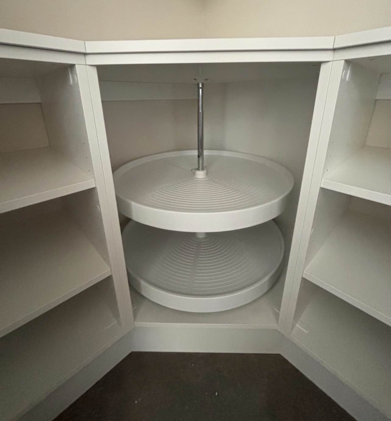 White custom corner closet with rotating shelves and open shelving units.