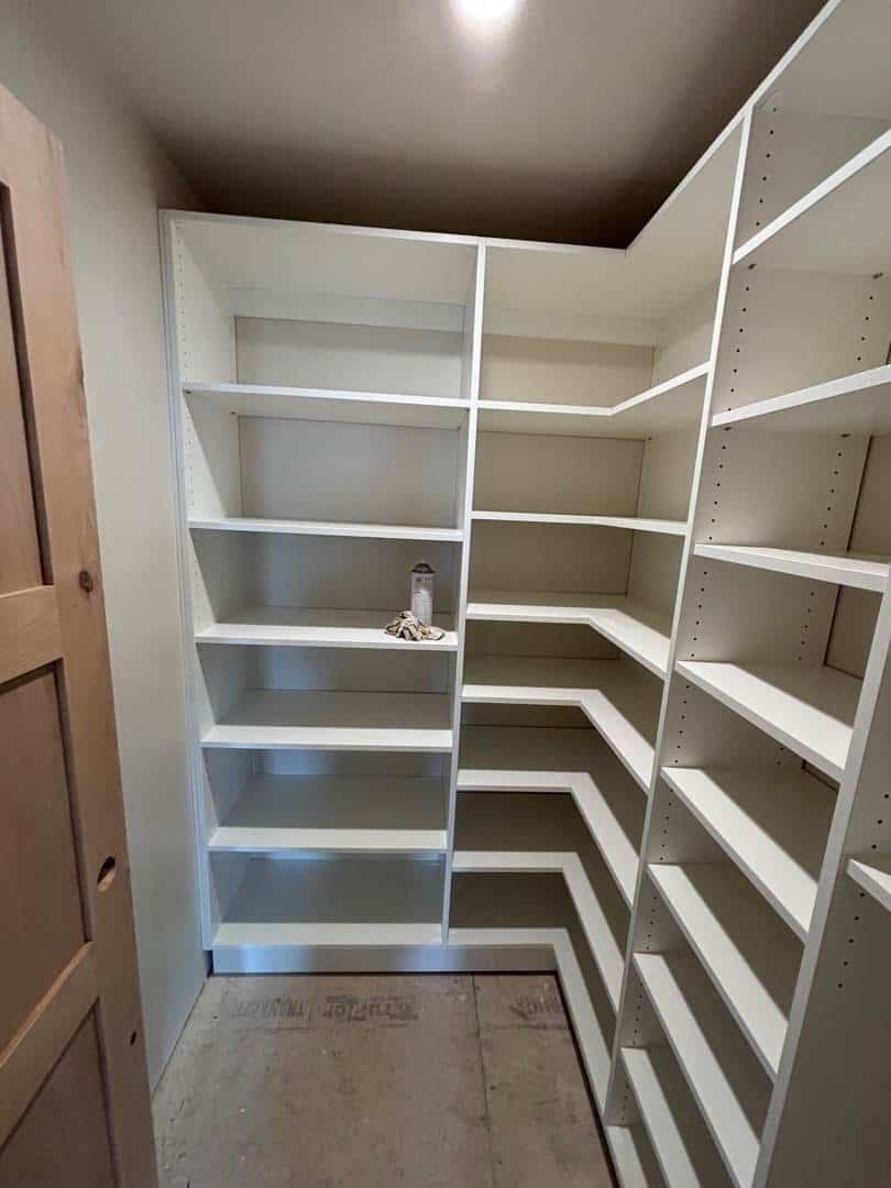 Custom white closet shelves and cabinets for organized storage in Durango.