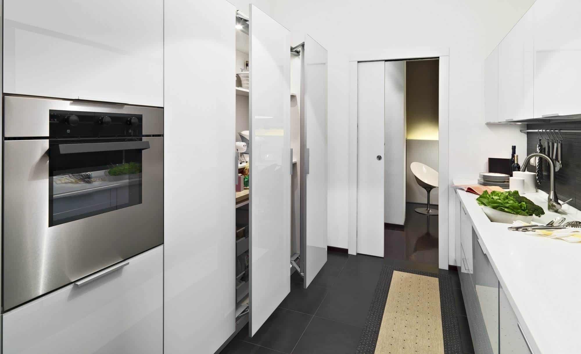 Contemporary white kitchen with built-in cabinets and appliances.