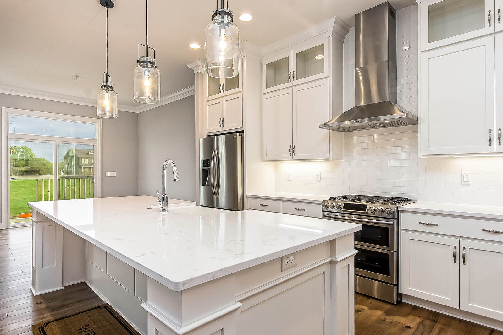 A luxury custom kitchen design featuring oversized island and stainless steel appliances.