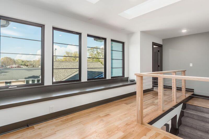 Hardwood flooring in a hallway with stairs.
