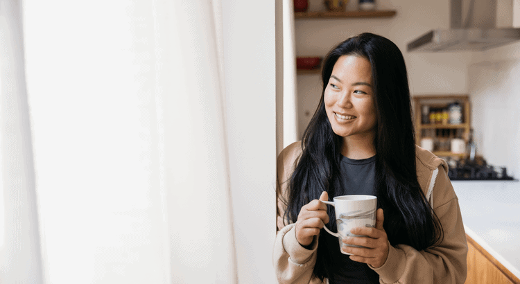 Walnut Creek real estate agent smiling with coffee in kitchen sunlit space.