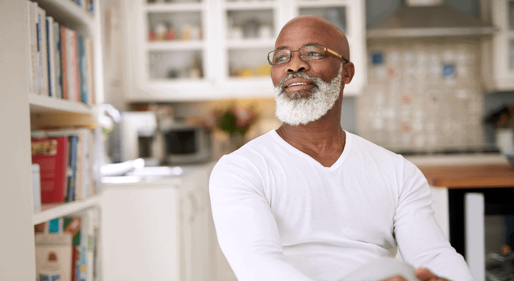 Warm smiling man in a cozy home kitchen, representing The Almaro Team's friendly real estate service.