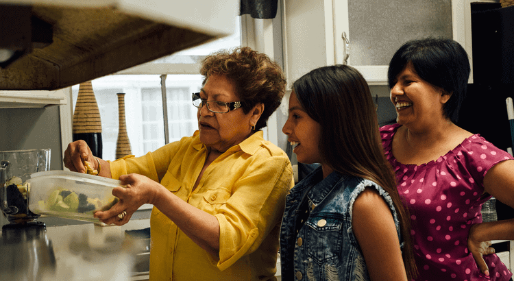 Community family cooking together in kitchen, happy diverse women and girl enjoying meal prep indoors, Walnut Creek CA.