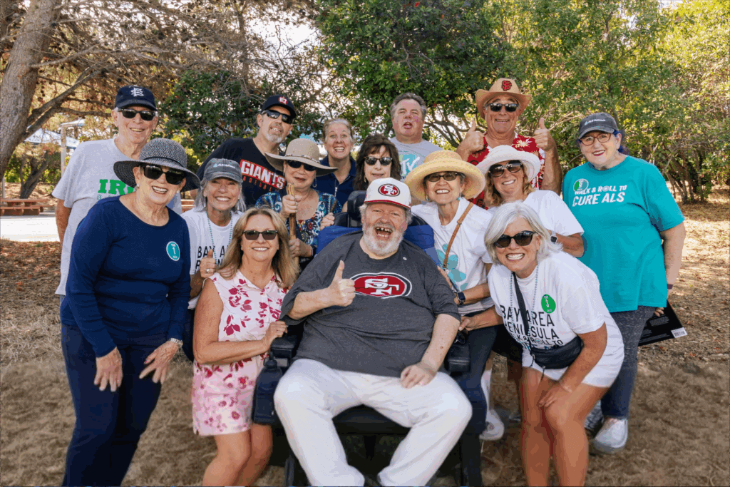 Group of diverse happy people outdoors wearing ALS awareness shirts and summer accessories.