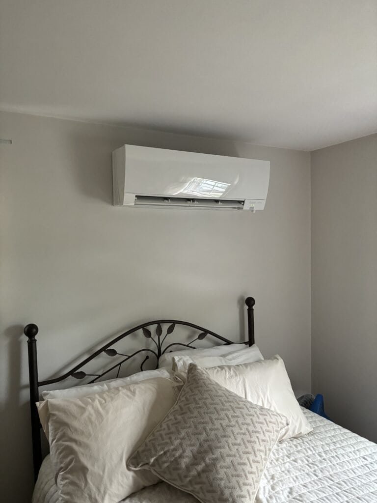 An air conditioner from JP Heating & Cooling helps keep this clean, comfortable bedroom cool and pleasant.