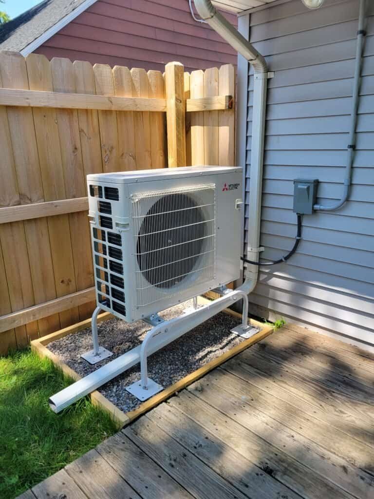 JP Heating & Cooling outdoor air conditioning unit on stand, showing a common cooling setup for West Seneca homes.