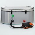 Electric air pump connected by hose to the inflation valve of the Vitalis 3 inflatable tub