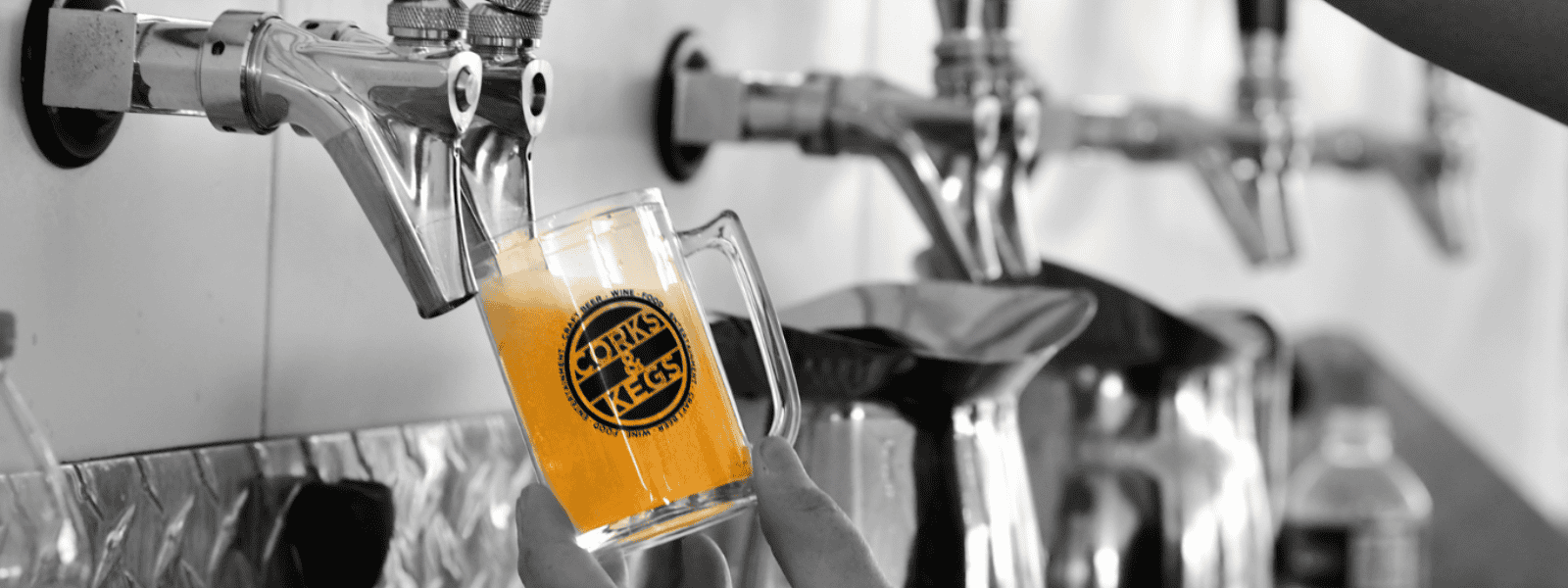 A beer being poured at Corks and Kegs Festival with taps in the background.