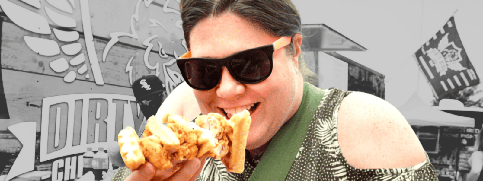 Person enjoying a large slice of pizza at Corks and Kegs festival.