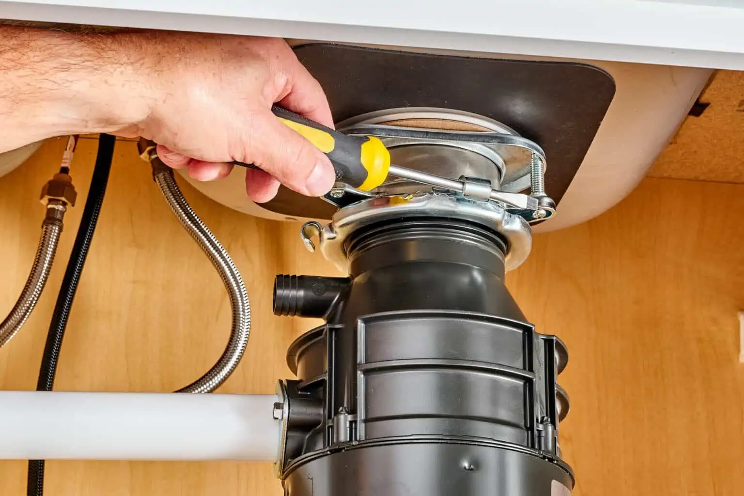 Clogged garbage disposal repair, plumber fixing kitchen sink drain, professional plumbing service, drain cleaning, Cornwell Plumbing, plumbing maintenance and repair, residential plumbing expert, plumbing troubleshooting.