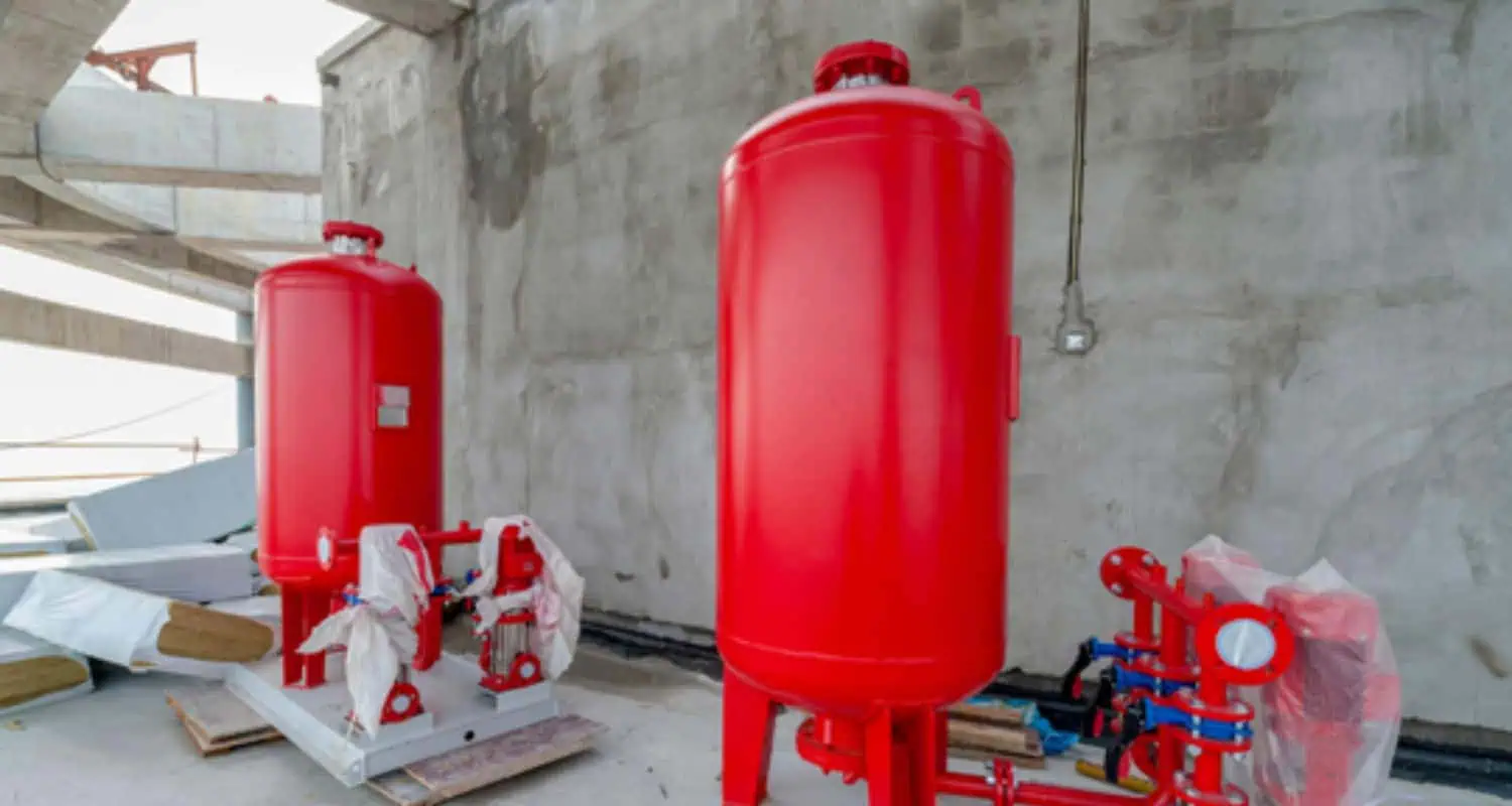 Metal fire sprinkler tanks with red paint on construction site for commercial fire protection systems.