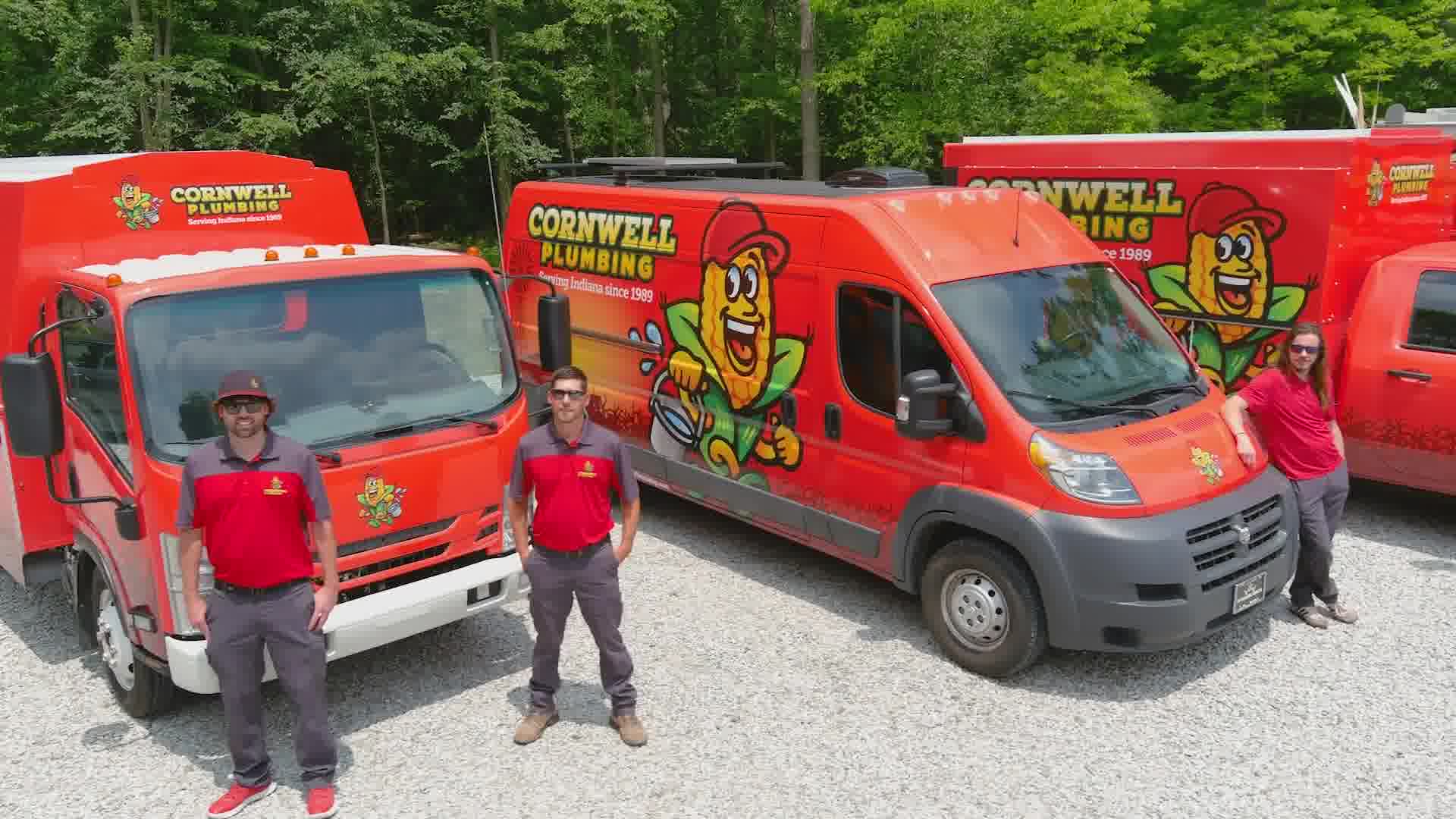 High-quality image of Cornwell Plumbing service trucks with team members, showcasing professional plumbing services and company branding in a lush outdoor setting.