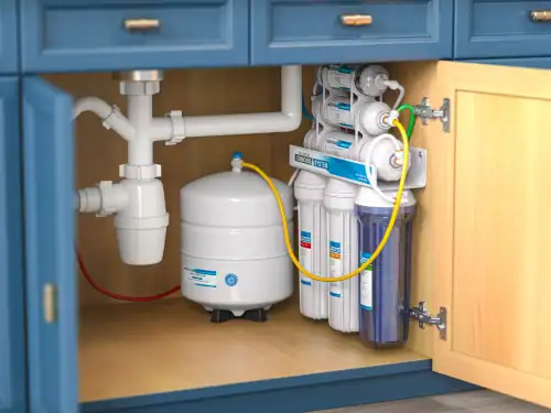 High-efficiency under-sink water filtration system installed in blue cabinetry for clean drinking water, plumbing services, and water filter installation by Cornwell Plumbing.