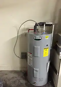 AC Smith water heater in a residential utility room, featuring plumbing connections and safety labels for reliable hot water supply.