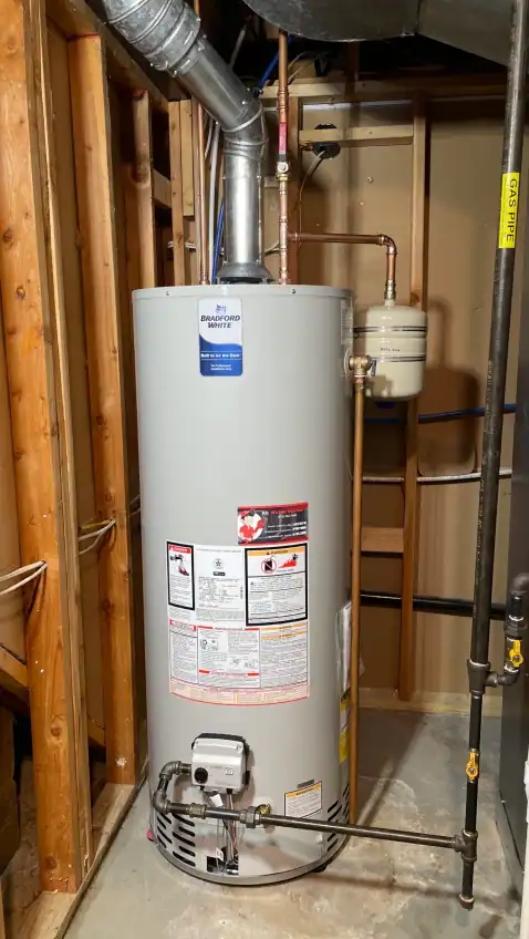 High-efficiency Bradford White water heater installed in a residential basement for reliable hot water supply. Featuring professional plumbing setup with copper and gas piping for optimal performance.