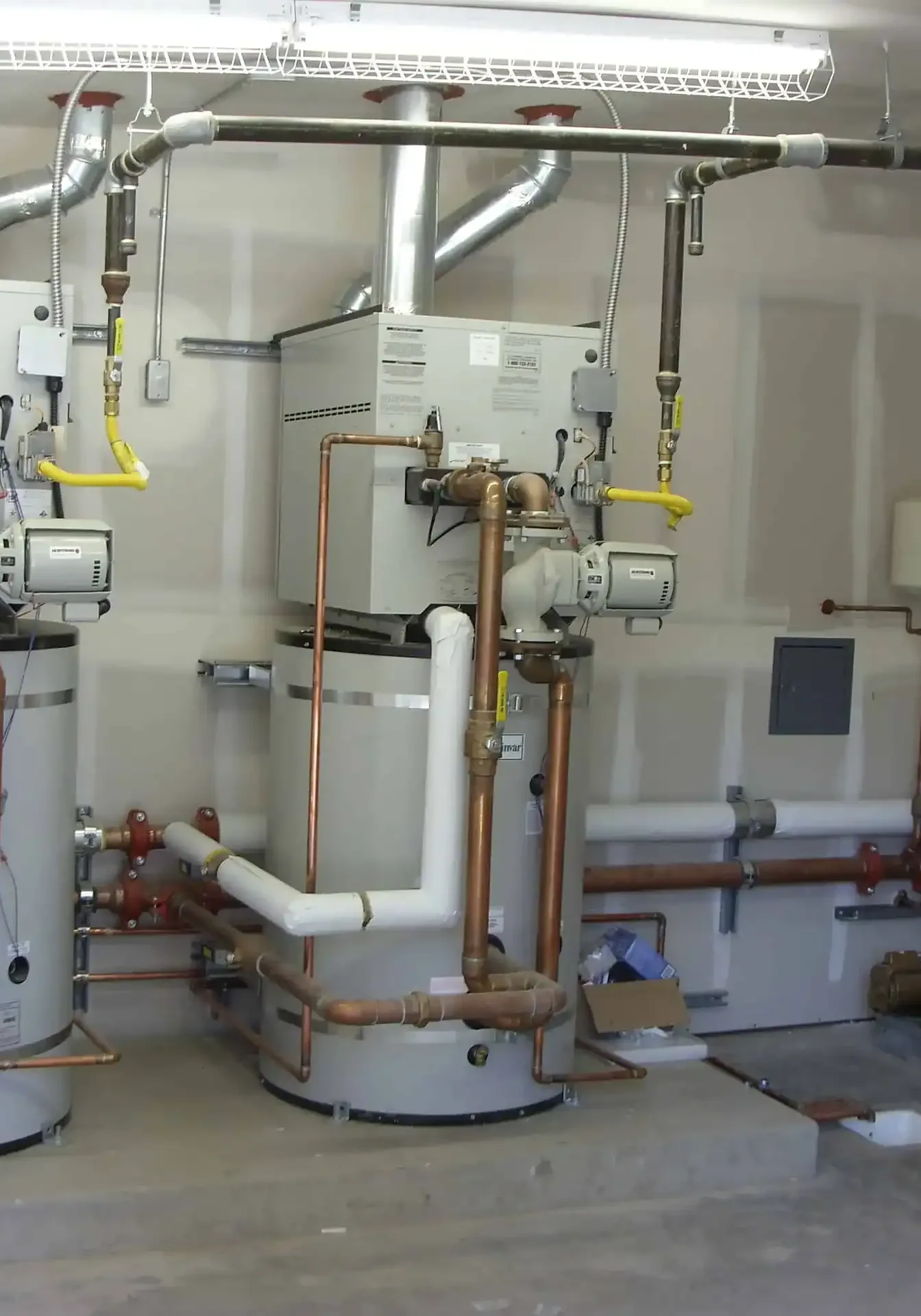 Boiler room with commercial water heating systems and plumbing components for efficient hot water supply. Plumbing experts install, maintain, and repair boiler equipment for residential and commercial properties.
